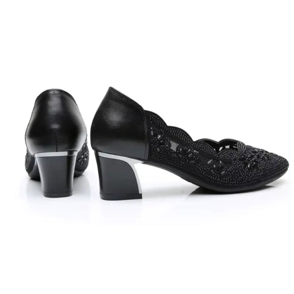Black high-heeled shoes with decorative details on a white background