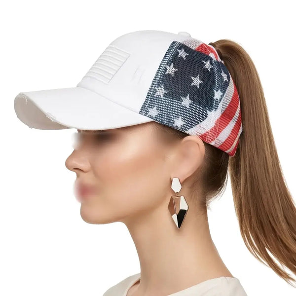 A woman in profile wearing a white baseball cap with an American flag pattern on the back panels, shown against a plain white background.