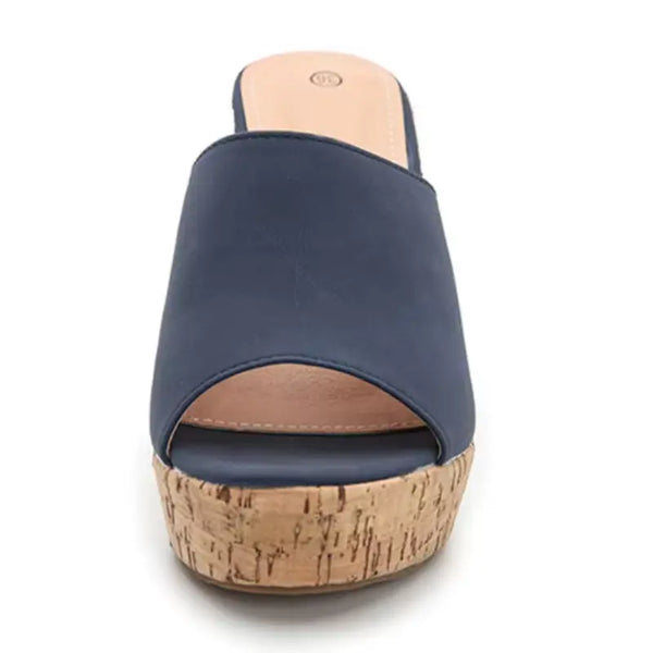 Navy blue sandal with cork wedge sole on a white background