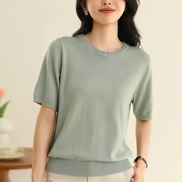 Woman wearing a light green sweater against a neutral background