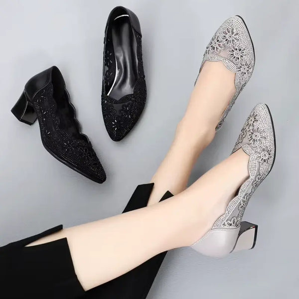 Black and silver high-heeled shoes on a gray background