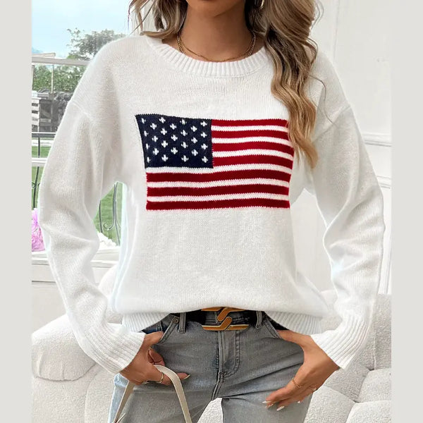 Person wearing a white sweater with an American flag design, sitting on a couch.