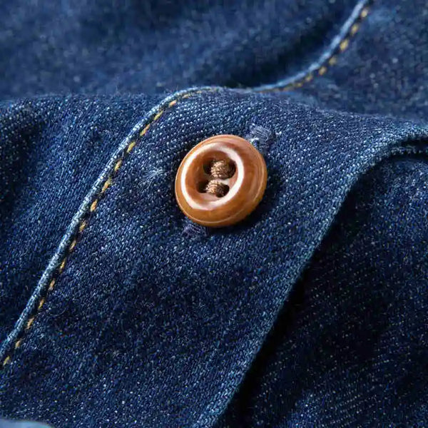 Close-up of a button on blue denim fabric