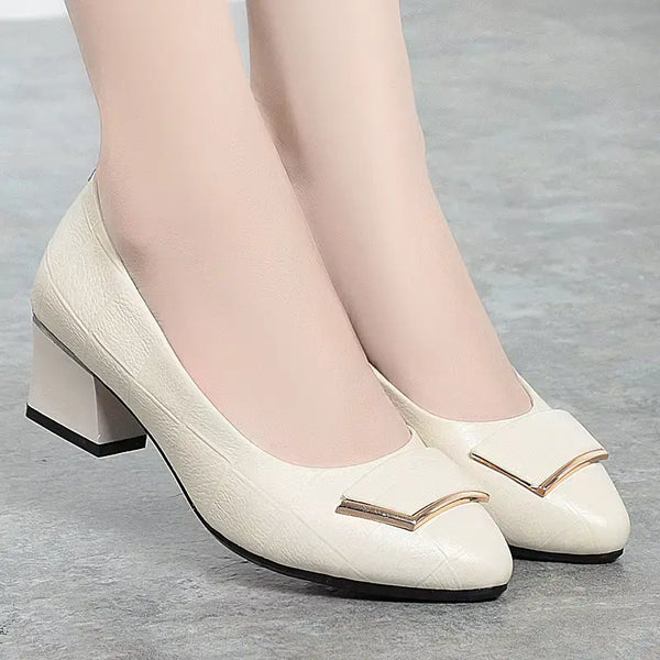 White shoes with gold accents worn by a person on a gray background