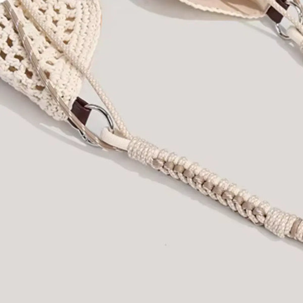 Close-up of a beige woven bag strap on a light gray background