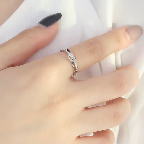 Silver ring on a finger with a white background