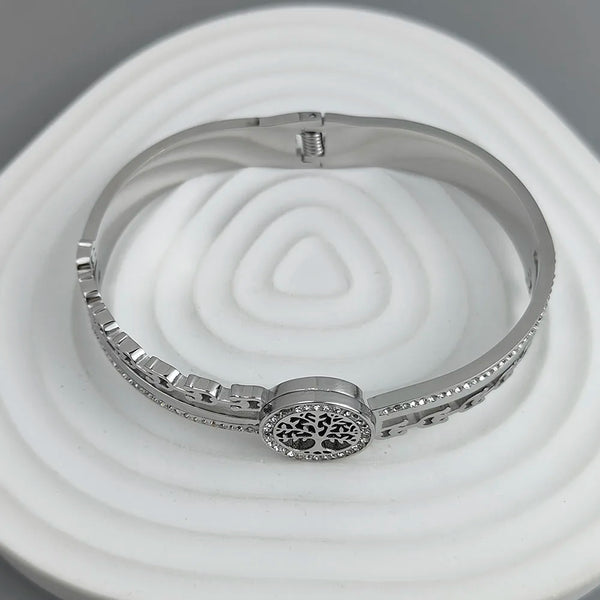 Silver bracelet with tree of life design on a white and gray background