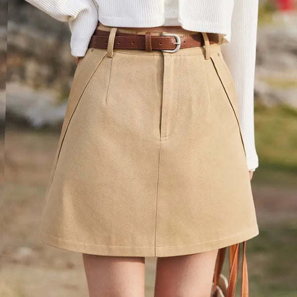 Beige skirt with a brown belt worn by a person outdoors.