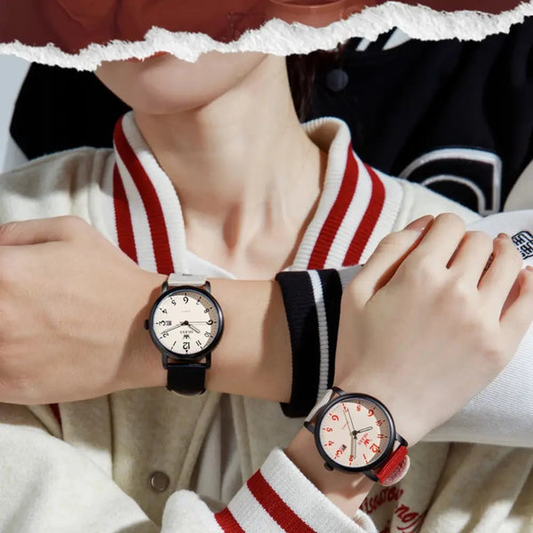 Two people wearing watches with different face designs, one with a black strap and the other with a red strap.
