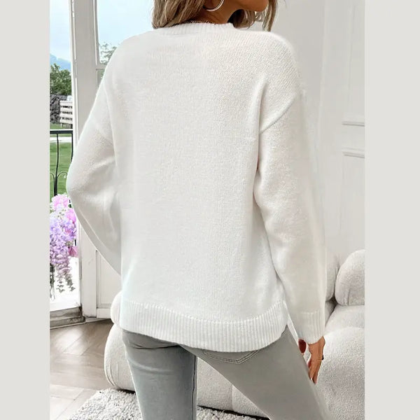 Person wearing a white sweater in a bright room with large windows.