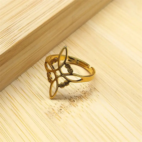 Gold ring with intricate design on a wooden surface