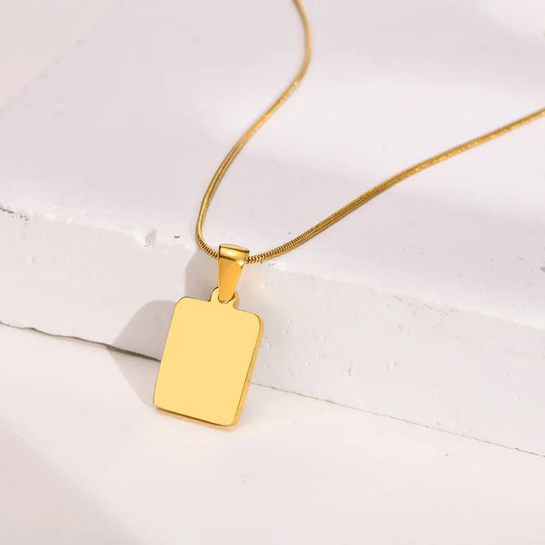 Gold pendant necklace on a white surface