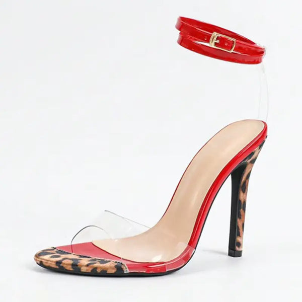 High-heeled shoe with red transparent sole and leopard print, paired with a red belt on a white background.