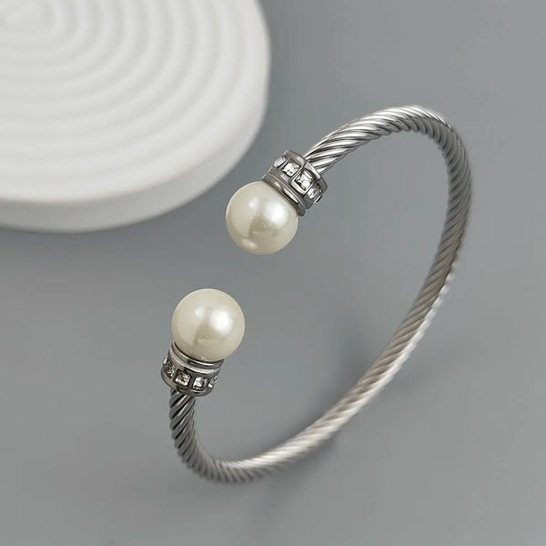 Silver bracelet with two pearls on a gray background
