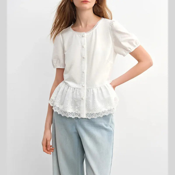 White lace-trimmed blouse worn by a person on a white background