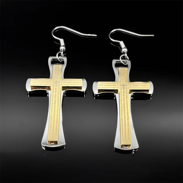 Cross-shaped earrings with gold and silver finish on a black background