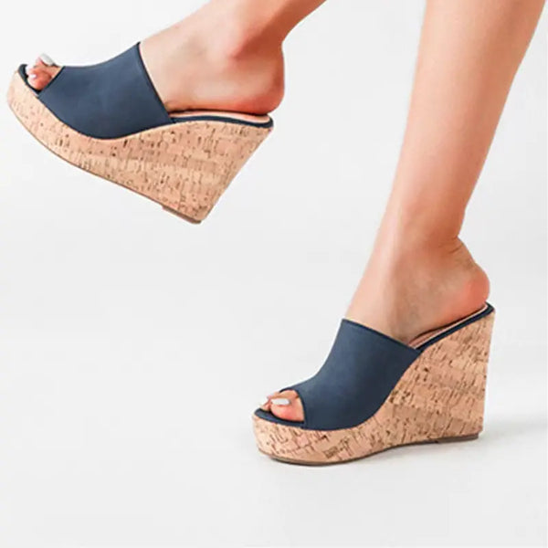 Navy wedge sandals with cork sole on a light background