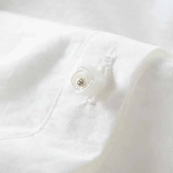 Close-up of a white shirt with a button on a light gray background