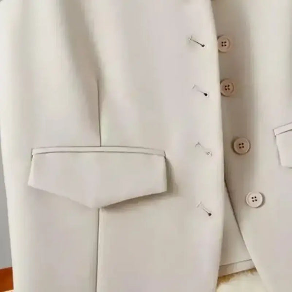 Close-up of a light gray suit jacket with buttons on a white background
