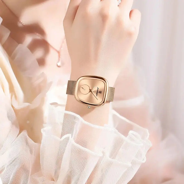 Gold wristwatch on a wrist with a soft, blurred background