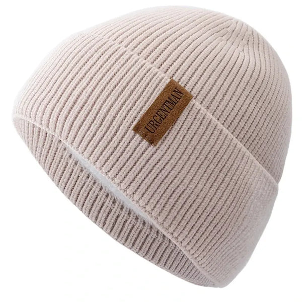 Beige knit beanie with a brown label on a white background