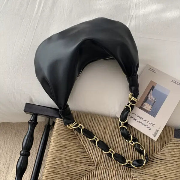 Black satin headband with gold chain on a white surface