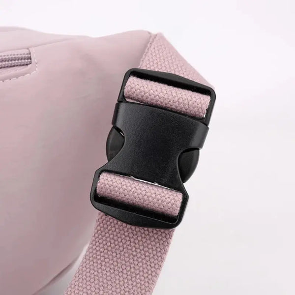 Close-up of a pink bag with a black buckle on a light gray background