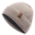 Beige knit beanie with a brown leather patch on a white background