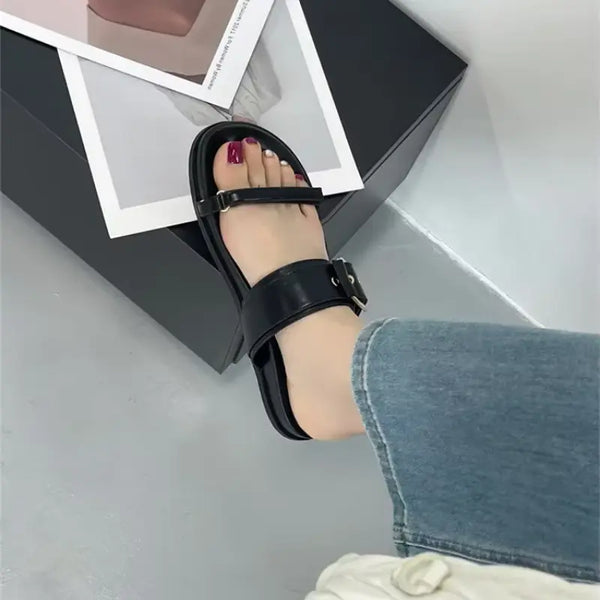 Black sandal worn with a gray background