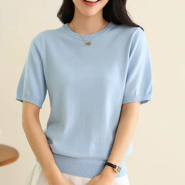 Light blue short-sleeve sweater worn by a person on a beige background
