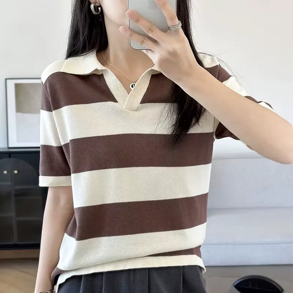 Person wearing a brown and beige striped shirt taking a mirror selfie.