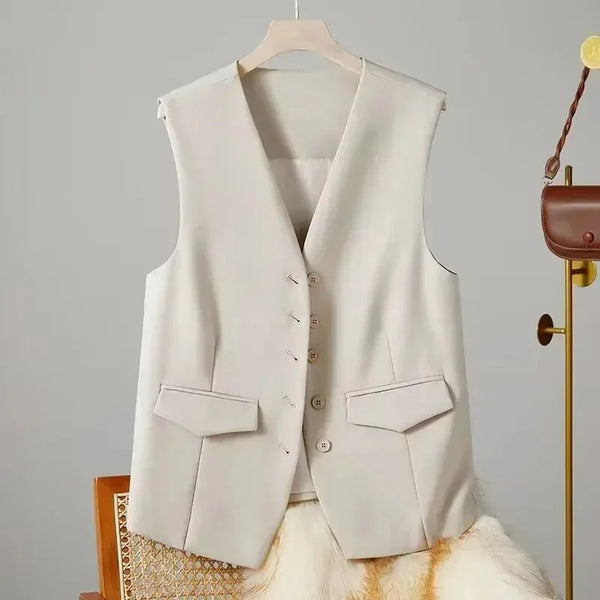 Beige vest on a hanger against a neutral background