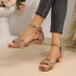 Rose gold glittery sandals worn with gray jeans on a neutral background