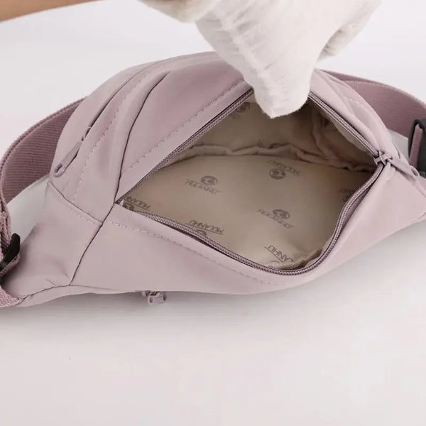 Close-up of a pink baby carrier with visible brand logo on a white background