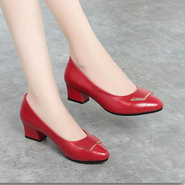 Red high-heeled shoes with a gold buckle on a gray background