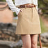 Person wearing a beige skirt with a blurred natural background