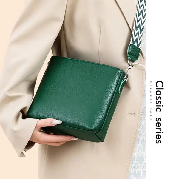 Green handbag held by a person wearing a beige coat, with 'Classic series' text on the side.
