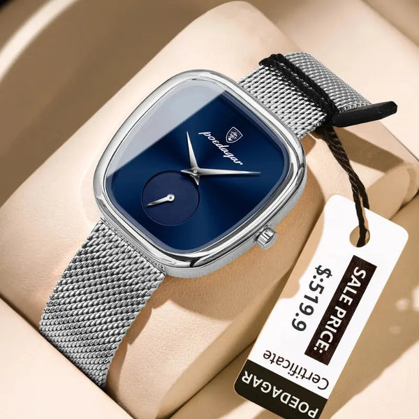 Silver watch with blue face on a beige surface, featuring a visible tag with a sale price.