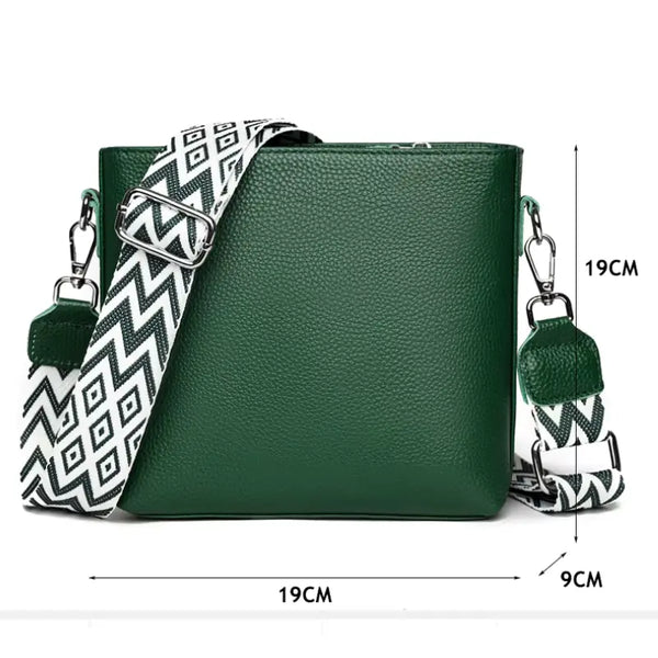 Green handbag with a patterned strap and measurements on a white background