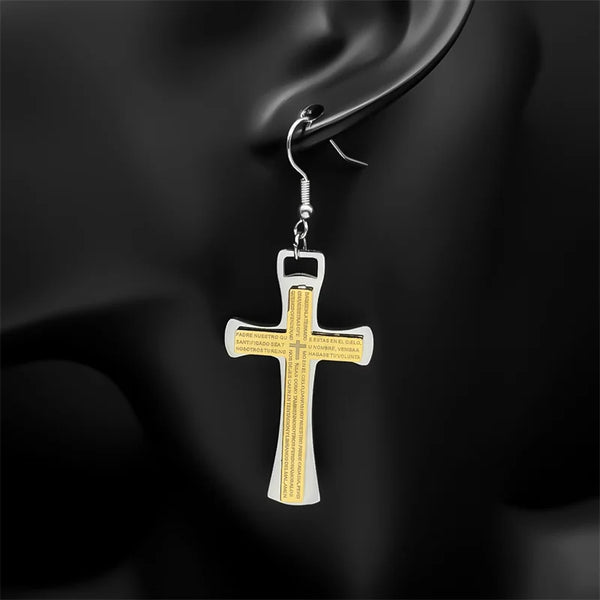 Cross-shaped earring with gold and silver design on a dark background