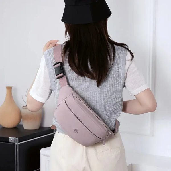 Person wearing a pink crossbody bag in an indoor setting
