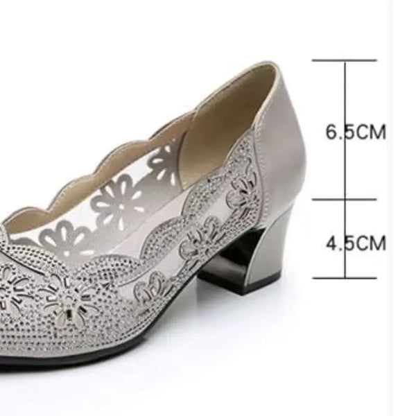 Silver high-heeled shoe with laser-cut design and measurements on a white background