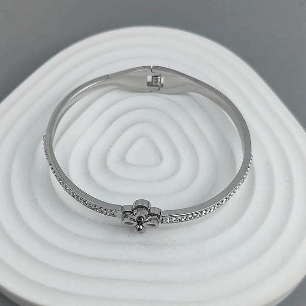 Silver bracelet with small stones on a white and gray background