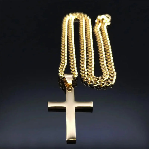 Gold cross pendant on a gold chain against a dark background
