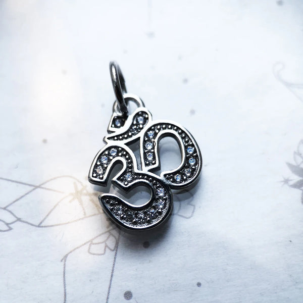 Silver pendant with gemstones on a light background