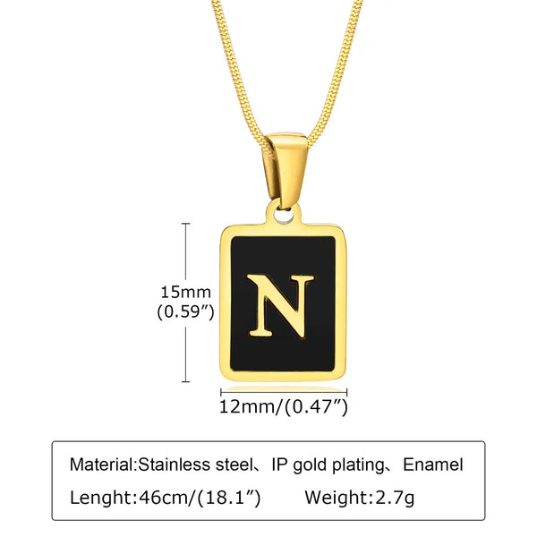 Gold necklace with a black square pendant featuring the letter 'N', showing measurements and material details.