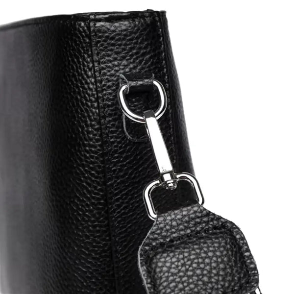 Close-up of a black leather boot with a metal zipper pull.