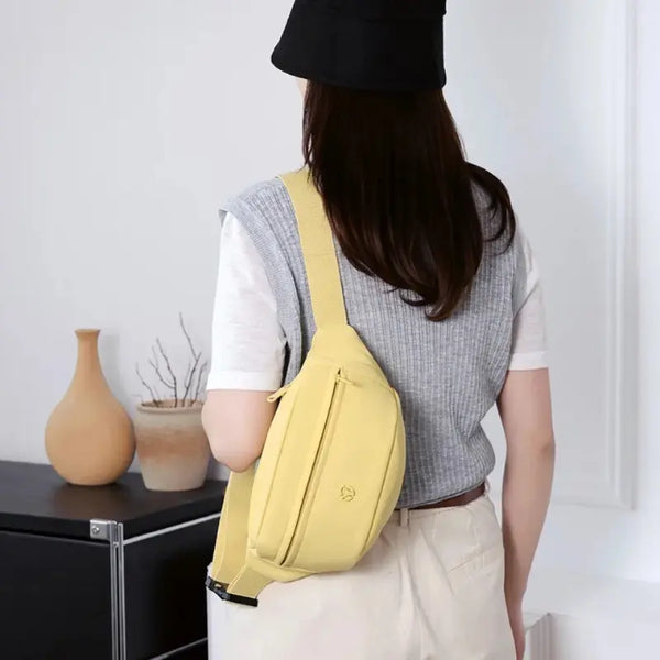 Person wearing a yellow sling bag in a minimal indoor setting