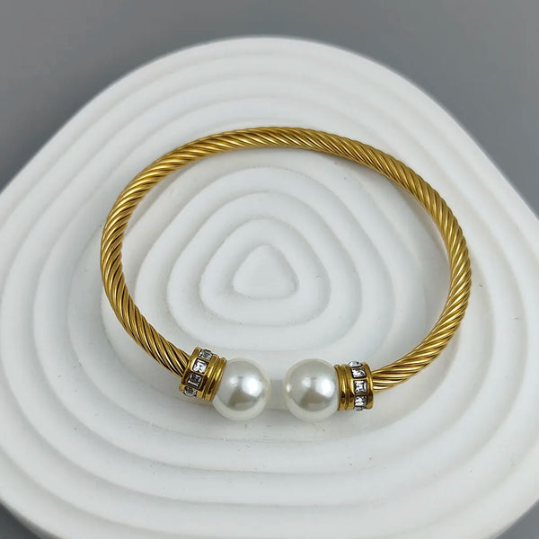 Gold bracelet with pearls on a white and gray background