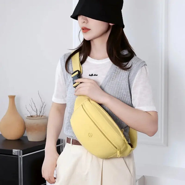 Person wearing a yellow crossbody bag indoors
